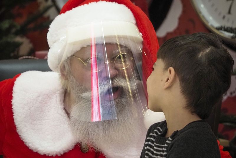 St.Petersburg:An actor dressed as Santa Claus and wearing a face mask to protect against coronavirus infection speaks with a boy during the New Year celebration in a shopping mall in St.Petersburg, Russia, Saturday, Jan. 2, 2021.AP/PTI Photo